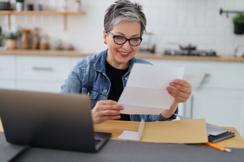Female at laptop with paperwork
